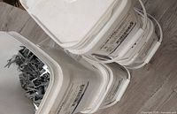 Overview of three white pails with labels visible and one open lid showing staples