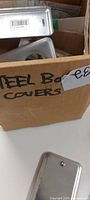 cardboard box labeled steel box covers showing contents