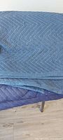 Stack of blue quilted moving blankets