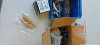 Blue bin with angle brackets, box with plastic end caps, lock washers, wall anchors, small fastener box