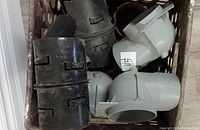 Crate showing mix of grey PVC elbows and black ABS couplers