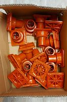 box containing multiple orange plastic rebar caps