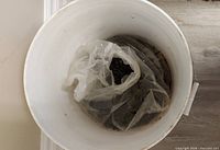 Overhead view of pail showing plastic liner filled with screws