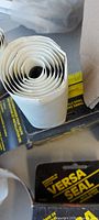 Rolled white-backed butyl tape beside Versa Seal boxes