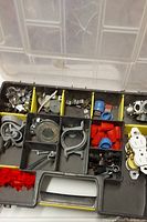 Toolbox tier with assorted metal brackets, clamps, washers, wire nuts, wall anchors, electrical outlets