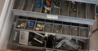 Open toolbox showing upper tray compartments with various connectors, screws and small hardware