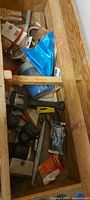 View inside wooden toolbox showing assorted tools and hardware