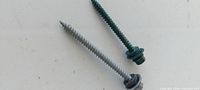 Two roofing screws showing green and galvanized finishes with washers