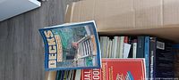 Open box filled with assorted construction reference books, top book 'Decks' visible