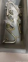 U-bolts, nuts, washers and threaded rod inside grey tray