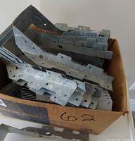 Box containing stack of galvanized face-mount joist hangers