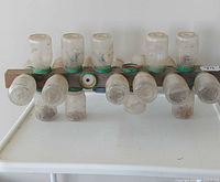 Front view of wooden rack showing all fourteen jars attached and contents visible