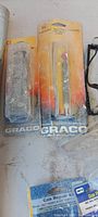Two sealed Graco blister packs (filter, tip) on dusty cards