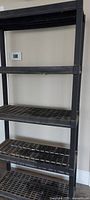 Full view of shelving showing five tiers and plastic grid shelves
