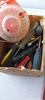 Cardboard box with screwdrivers, mallet and circular organizer