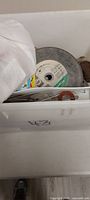 top view of tote with abrasive wheel and contents visible