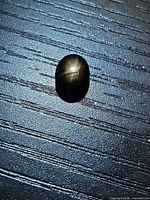 Top view of oval black star sapphire showing 6-ray star