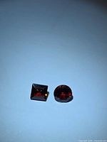 Square and round garnet pair under lighting