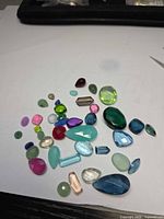 Group of assorted coloured faceted gemstones on white background