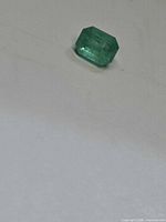 Loose octagon-cut emerald on flat surface