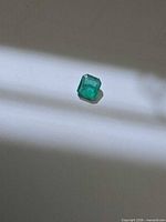 Loose octagon-cut emerald on neutral background