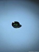 Front view of oval cut deep green sapphire