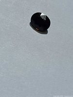 Top view of faceted dark cognac tourmaline on white background