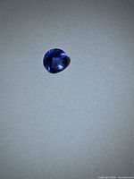Round blue tanzanite on neutral background