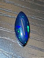 Top view of the marquise cabochon opal showing blue and green play of colour
