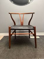 Front view of oak Wishbone chair with black leather seat