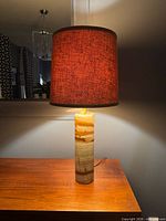 Full view of illuminated lamp showing shade and onyx base