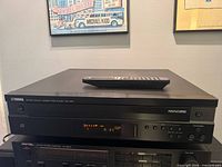 Front view of Yamaha CDC-585 CD changer with remote on top