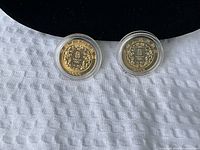 Front views of both 2008 gold-plated Olympic coins in capsules