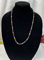 Necklace displayed on black bust showing bead colors and arrangement
