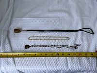 All three necklaces laid out beside measuring tape for scale