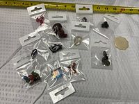 All pouches and loose carved flower pendant laid out beside measuring tape