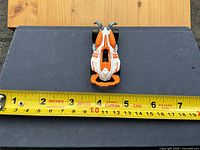 Top view of car on blue surface with tape measure showing roughly 3 inch length