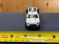 Front view of white/blue Diesel Duty police car on ruler showing approx 7 cm length