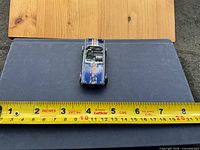 Top view showing entire car and measuring tape indicating length