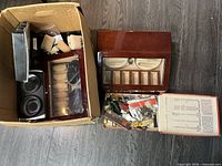 Open box showing black double winder, wooden winder and partial view of parts tray