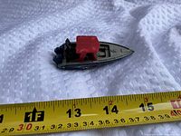Left side view of speedboat next to ruler showing length