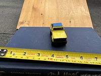 Front view showing yellow body, open top, blue roof section and size reference