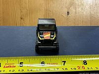 Front view of die-cast Jeep pickup with measuring tape showing ~3-inch length