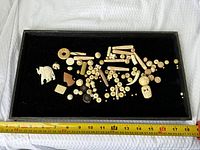 Overview of entire lot on black tray showing quantity and ruler for scale