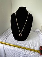 Full view of beaded necklace on display bust showing pendant and bead pattern