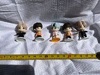 Front view of five chibi PVC figurines with measuring tape