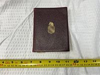 Front cover showing gold crest and burgundy cover