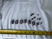 Nine large chevron beads and small bead group with measuring tape for scale