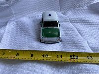 Front view showing green hood, grille, blue roof light, tape measure indicating size