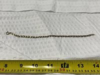 Full bracelet laid beside tape measure showing length